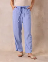 Pantalón largo de lino y rayón a rayas verticales grises y blancas. Tiene pretina elastizada con lazo de ajuste, bolsillos delanteros y traseros.