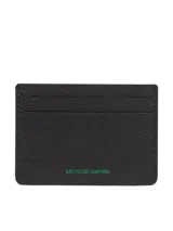 Tarjetero compacto de cuero con acabado granulado en color negro. Presenta múltiples ranuras exteriores para tarjetas y el parche distintivo de Tommy Jeans en el frente.