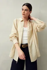 Camisa color beige de lino con botones de nácar y detalles de calados tipo vainillas.