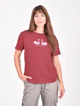 Remera blanca de manga corta con cuello redondo y un estampado artístico en tonos rojo oscuro y negro que simula una figura femenina con pantalón ancho a rayas.