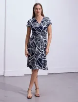 Vestido midi de seda fría con estampado abstracto en blanco y azul marino, escote en V cruzado, mangas cortas y cintura con hebilla decorativa.