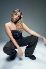 Top strapless de jean negro con hebillas metálicas ajustables y cierre en la espalda.