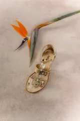 Sandalias bajas de cuero color marrón con múltiples tiras y hebillas metálicas ajustables.