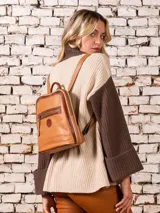 Mochila de cuero color camel con cierre superior y bolsillo frontal con cierre.
