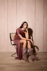 Vestido corto de lycra elastizada color marrón, con diseño asimétrico de un solo hombro y cuerpo fruncido. Presenta un detalle de tela larga colgante en el lateral que aporta movimiento.