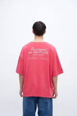 Remera color coral con estampa en la espalda con la frase "Real fabric for real people".
