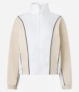 Campera deportiva de mujer, color blanco y beige, con cuello alto y cierre frontal. Presenta frisos contrastantes en color marrón que definen el diseño de bloques de color en el torso y mangas.
