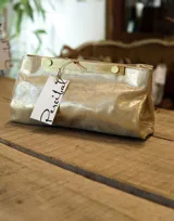 Sobre de cuero color dorado con herraje metálico dorado.