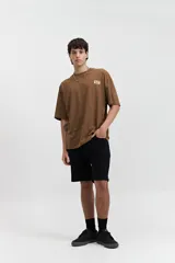 Remera color crema de manga corta con corte boxy, cuello redondo y logo estampado en el pecho.