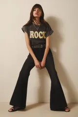Pantalón jean negro de tiro medio y calce ajustado hasta la rodilla, con pierna acampanada y ruedo ancho.