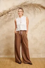 Pantalón ancho color marrón de lino con cinto y pretina con elástico en la parte de atrás.