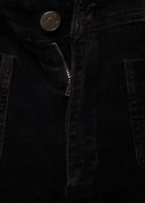 Pantalón culotte de pana color negro, tiro alto, con cierre de cremallera y botón, trabillas, dos bolsillos de parche delanteros y dos bolsillos de parche traseros.