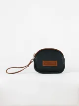 Monedero pequeño color crudo, con cierre superior y tira de cuero marrón.