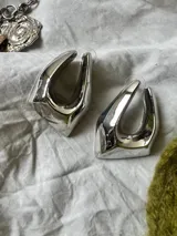 Pendientes plateados con forma irregular, fabricados en aleación.