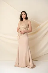 Vestido largo color nude de lycra, con apliques bordados en el corsé y cola corta.
