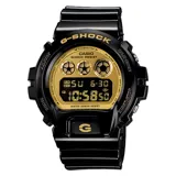 Reloj Casio G-Shock modelo DW6900CB-8DS, con caja y correa de resina color negro y esfera dorada.
