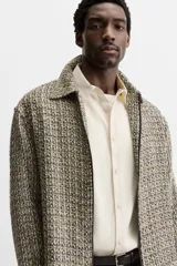 Sobrecamisa de tweed multicolor con cuello solapa, cierre frontal con cremallera, bolsillos laterales y puños abotonados.