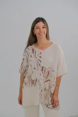 Blusa beige con estampado de hojas marrones, cuello en V y corte holgado.
