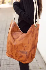 Cartera tipo tote bag de cuero color marrón con efecto desgastado, con asas trenzadas de cuero crudo.