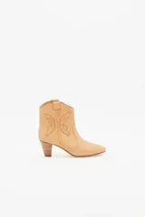 Botín de cuero color beige, estilo cowboy, con bordados en forma de mariposa en los laterales y taco de madera.