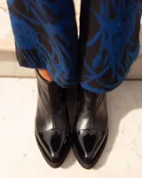 Botas cortas de cuero color marrón con textura de reptil en la puntera y caña, y textura de cocodrilo en el tobillo.