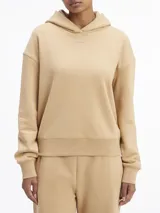 Buzo color beige de corte holgado, con capucha y logo de Calvin Klein bordado en el pecho.