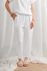 Pantalón blanco de lino, de corte holgado con bolsillos laterales.