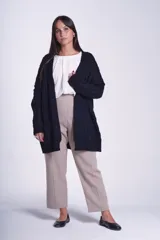 Saco tejido color crema con diseño de ochos y bolsillos frontales.