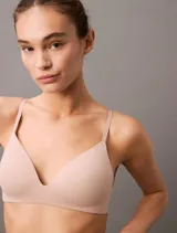 Conjunto de ropa interior color piel, compuesto por un sujetador sin aro y una bombacha tipo bikini. El sujetador tiene tirantes finos y ajustables, y la bombacha es de corte clásico.