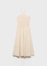 Vestido midi color crudo, con escote halter y tirantes finos. El corpiño es ajustado y texturizado, mientras que la falda es amplia y fluida.