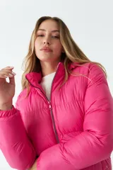 Campera puffer corta color fucsia, con cierre frontal y cuello alto.