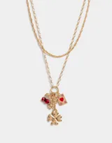 Set de 2 collares cortos dorados con dijes colgantes: cerezas rojas, oso dorado, naipe de corazón y trébol de cuatro hojas dorado.