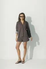 Camisa marrón a rayas verticales negras y rojas, de corte relaxed, con cuello clásico y botones al tono.