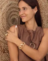 Brazalete dorado con diseño de círculos irregulares.