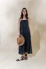 Vestido largo color crudo con rayas verticales finas, breteles finos regulables, escote recto con bordado artesanal y tajos laterales.