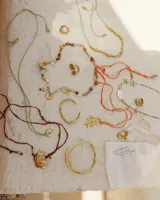 Collar corto con cuentas de piedra natural multicolor, perlas de río irregulares y dijes de bronce con forma de coral.