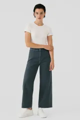 Pantalón de jean color gris oscuro, de corte ancho y tiro alto, con ruedo desflecado.