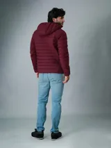 Campera acolchada Calvin Klein color bordó con capucha y cierre frontal con cremallera. Tiene bolsillos laterales con cremallera y logo de la marca en el pecho y en la manga.