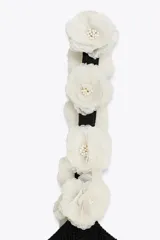 Top negro de punto con escote redondo y tirantes anchos decorados con flores blancas y abalorios.