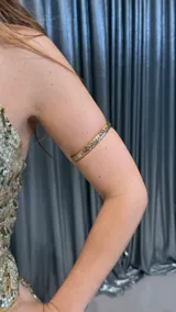 Brazalete dorado con diseño grabado.