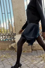 Minifalda azul petróleo de satén con encaje negro en el frente, corte al bies y cierre lateral invisible.