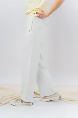 Pantalón jogger wide fit color amarillo pastel, confeccionado en algodón suave, con cintura elástica con cordón ajustable y bolsillos laterales funcionales.