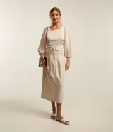 Blusa color beige confeccionada en viscosa, con escote cuadrado, mangas largas abullonadas y puños ajustados.