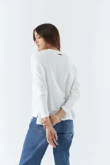 Remera blanca de algodón con mangas largas, cuello redondo y estampado frontal con la palabra 'Faith' en letras de diferentes colores.