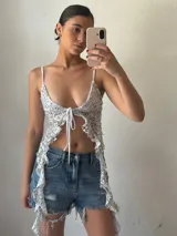 Top plateado con lentejuelas, breteles finos y lazo ajustable en el frente.