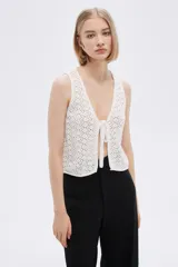 Top sin mangas de algodón color blanco, tejido al crochet, con escote en V profundo y lazo de ajuste en el frente.