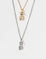 Set de dos collares de cadena metálica, uno plateado y otro dorado, con dije de oso y cristal.
