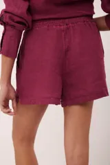 Short color borgoña de lino italiano con elástico en la cintura y bolsillos laterales.
