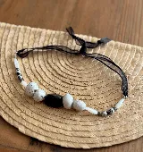 Collar tipo gargantilla de piedras naturales en tonos blancos y amarillo, con terminación en cinta o cuero y largo ajustable.