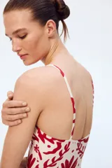 Traje de baño enterizo blanco con estampado de motivos marinos en color rojo.